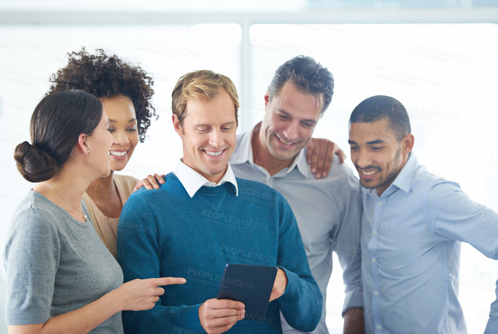 Buy stock photo Shot of a group of colleagues using a digital tablet together