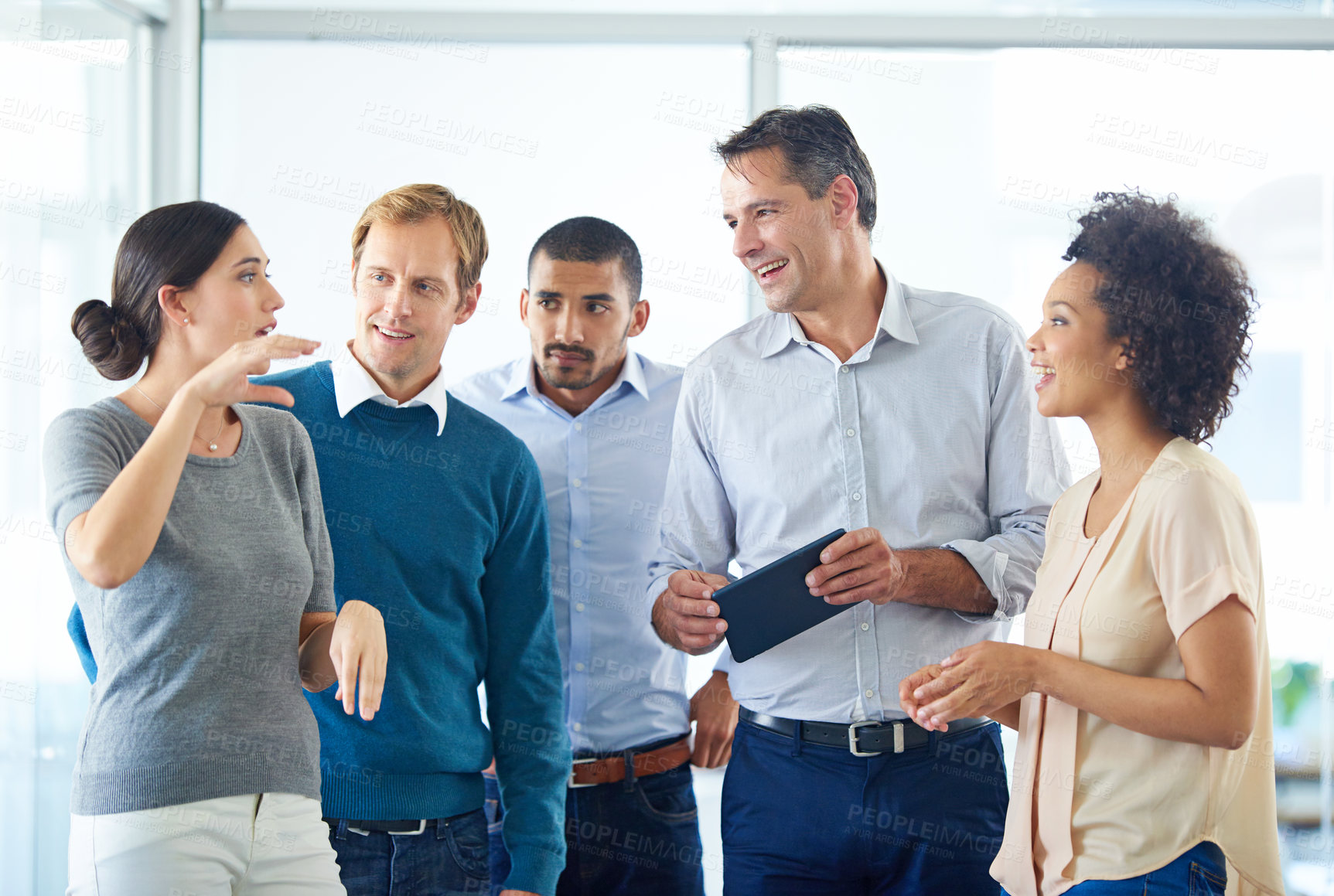 Buy stock photo Shot of a group of colleagues using a digital tablet together