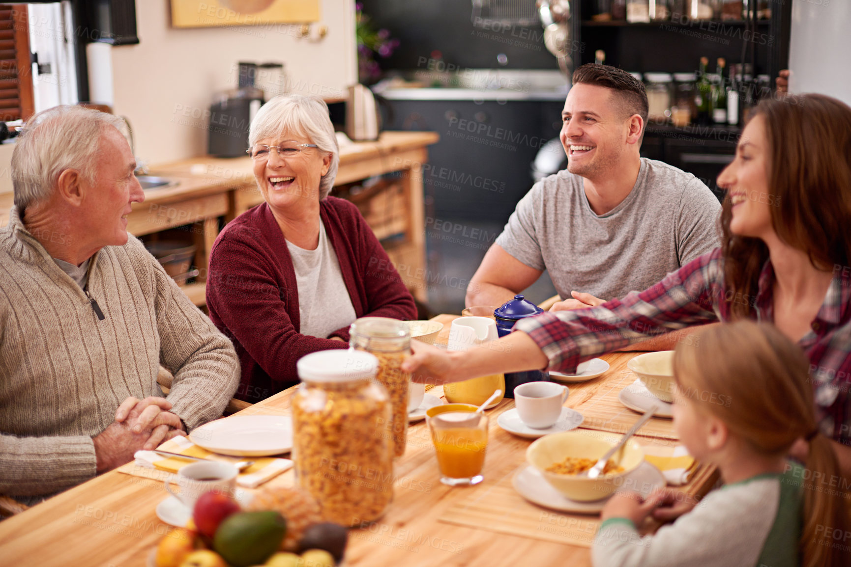 Buy stock photo Shot of a happy multi-generational family having breakfast together in the kitchen