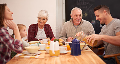 Buy stock photo Shot of a multi-generational family enjoying breakfast together in the kitchen