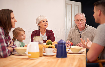 Buy stock photo Shot of a multi-generational family enjoying breakfast together in the kitchen
