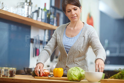 Buy stock photo Shot of an attractive woman preparing food in the kitchen