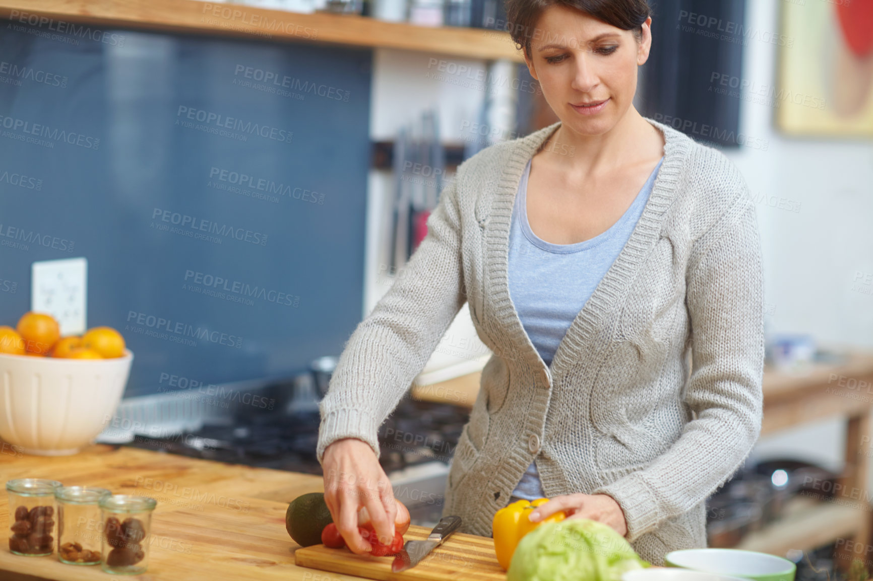 Buy stock photo Shot of an attractive woman preparing food in the kitchen