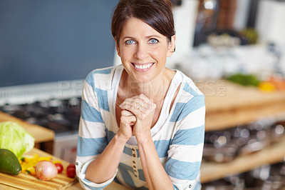 Buy stock photo Portrait of a beautiful woman leaning against the countertop in her kitchen