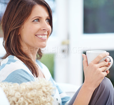 Buy stock photo Shot of a beautiful woman enjoying a cup of coffee at home