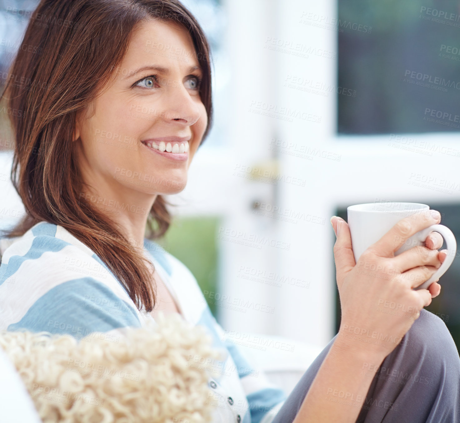 Buy stock photo Shot of a beautiful woman enjoying a cup of coffee at home