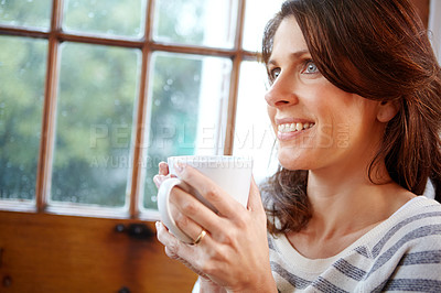 Buy stock photo Shot of a beautiful woman enjoying a cup of coffee at home
