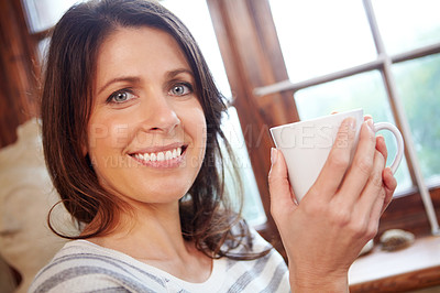 Buy stock photo Portrait of a beautiful woman enjoying a cup of coffee at home