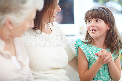 Buy stock photo Shot of a cute little girl chatting to her mother and grandmother at home