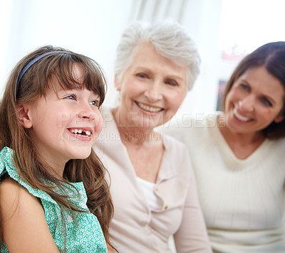 Buy stock photo Shot of a cute little girl spending time with her mother and grandmother at home