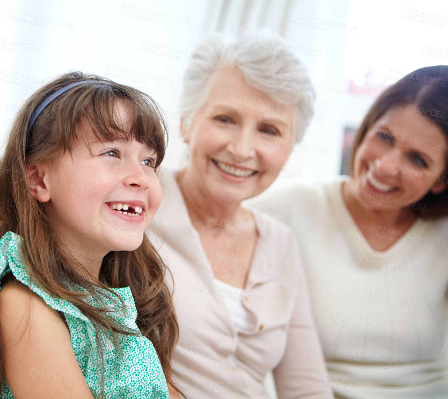 Buy stock photo Shot of a cute little girl spending time with her mother and grandmother at home