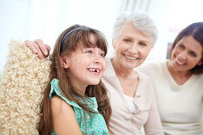 Buy stock photo Shot of a cute little girl spending time with her mother and grandmother at home