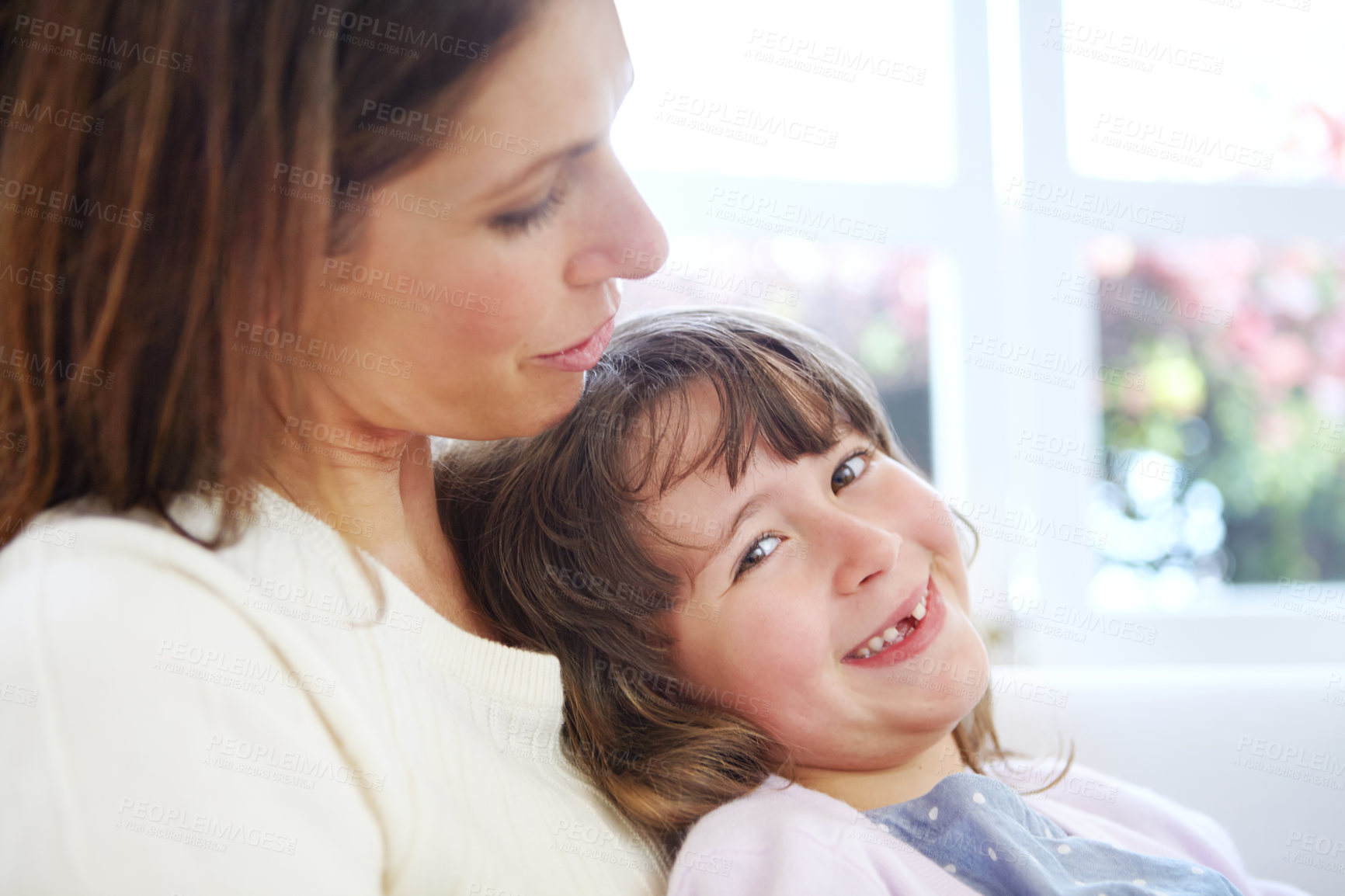 Buy stock photo Shot of an adorable little girl sitting on her mother's lap