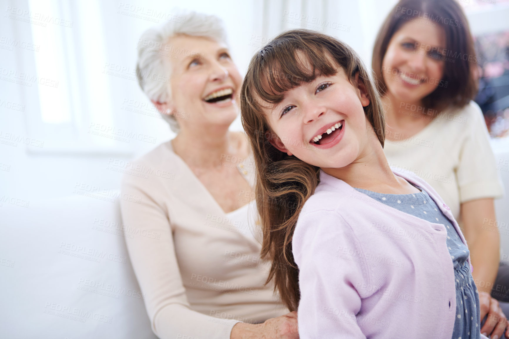 Buy stock photo Portrait of an adorable little girl with her mother and grandmother in the background