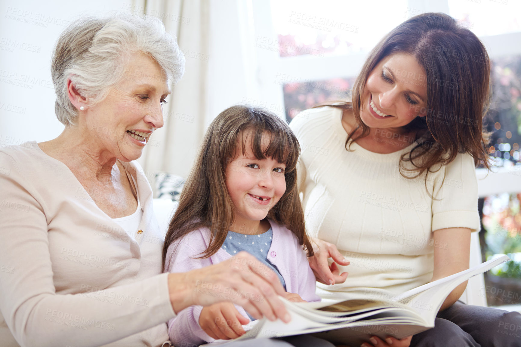 Buy stock photo Portrait, book and child with mom and grandmother on sofa in living room for bonding together. Happy, relax and girl with mother and senior woman reading fantasy story, novel or literature at home.