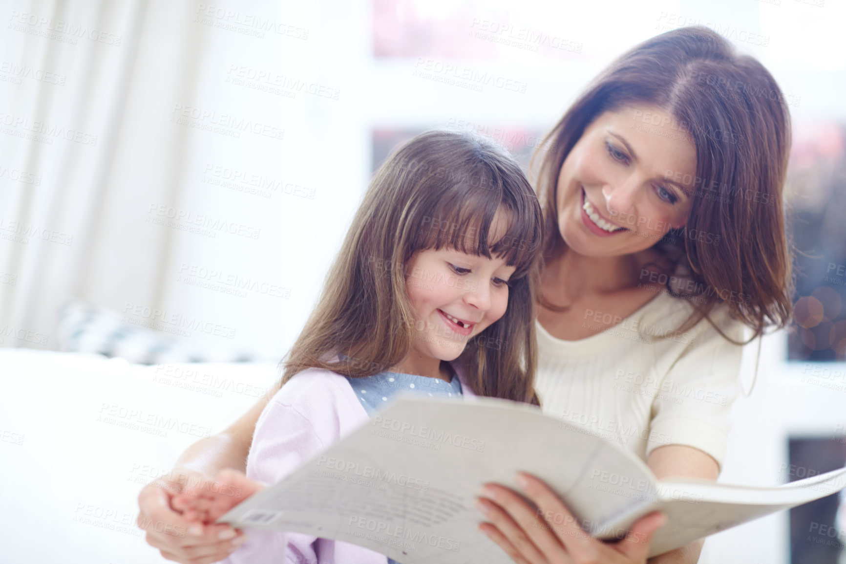 Buy stock photo Happy, book and child reading with mother on sofa in living room for bonding together. Smile, relax and girl kid enjoying fantasy novel, story or literature with mom on couch for learning at home.