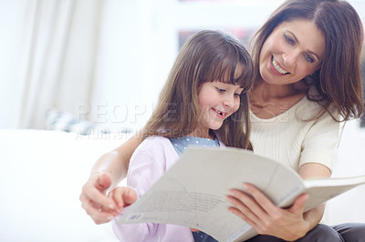 Buy stock photo Shot of mother and daughter reading a book together