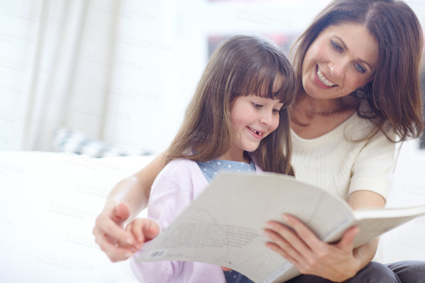 Buy stock photo Happy, book and child reading with mom on sofa in living room for bonding together. Smile, relax and girl kid enjoying fantasy novel, story or literature with mother on couch for learning at home.