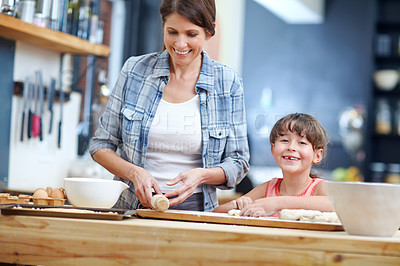 Buy stock photo Shot of a mother and daughter baking together in the kitchen