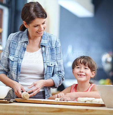 Buy stock photo Shot of a mother and daughter baking together in the kitchen