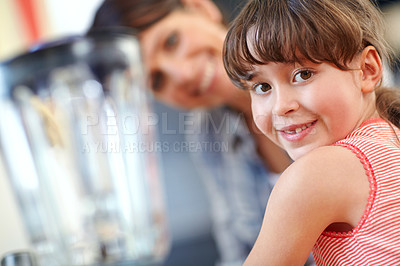 Buy stock photo Shot of a little girl smiling at the camera with her mother standing in the background