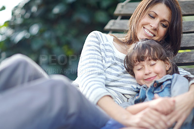 Buy stock photo Shot of a little girl napping in her mother's arms while lying on a hammock