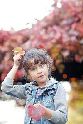 Buy stock photo Shot of a cute little girl playing with leaves outdoors