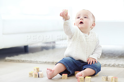 Buy stock photo An adorable little boy wearing casual clothing while playing with his blocks