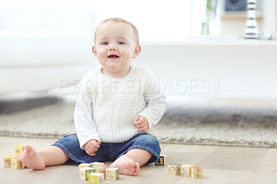 Buy stock photo An adorable little boy wearing casual clothing while playing with his blocks