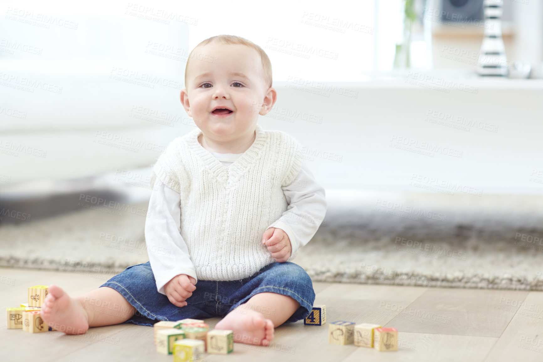 Buy stock photo An adorable little boy wearing casual clothing while playing with his blocks