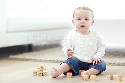 Buy stock photo An adorable little boy wearing casual clothing while playing with his blocks