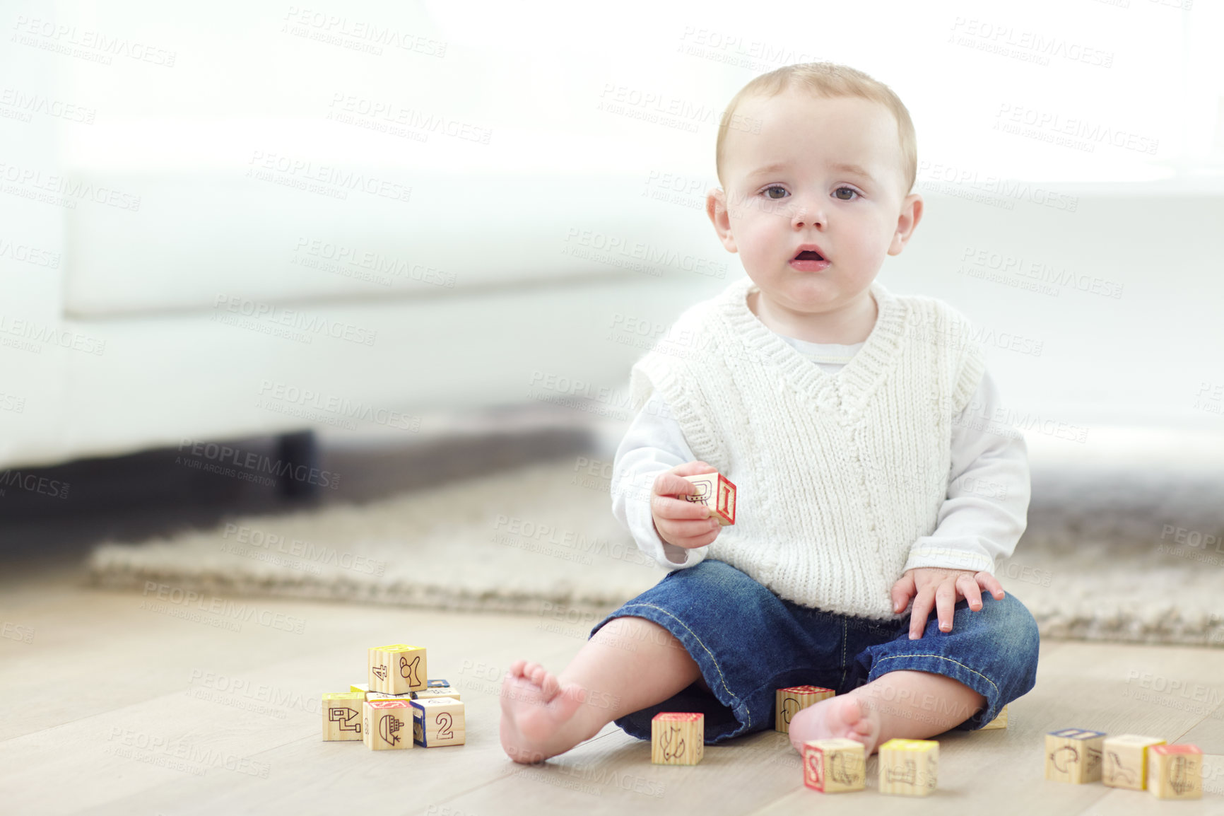 Buy stock photo An adorable little boy wearing casual clothing while playing with his blocks