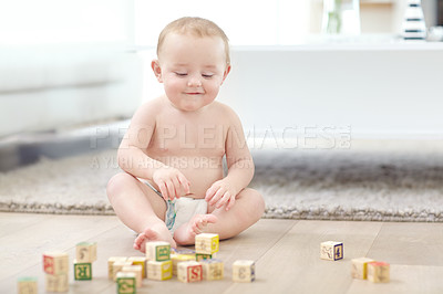 Buy stock photo Shot of an adorable little boy wearing his diaper while playing with his blocks