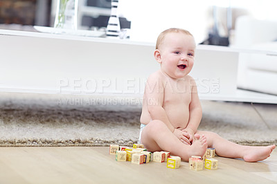 Buy stock photo Shot of an adorable little boy wearing his diaper while playing with his blocks