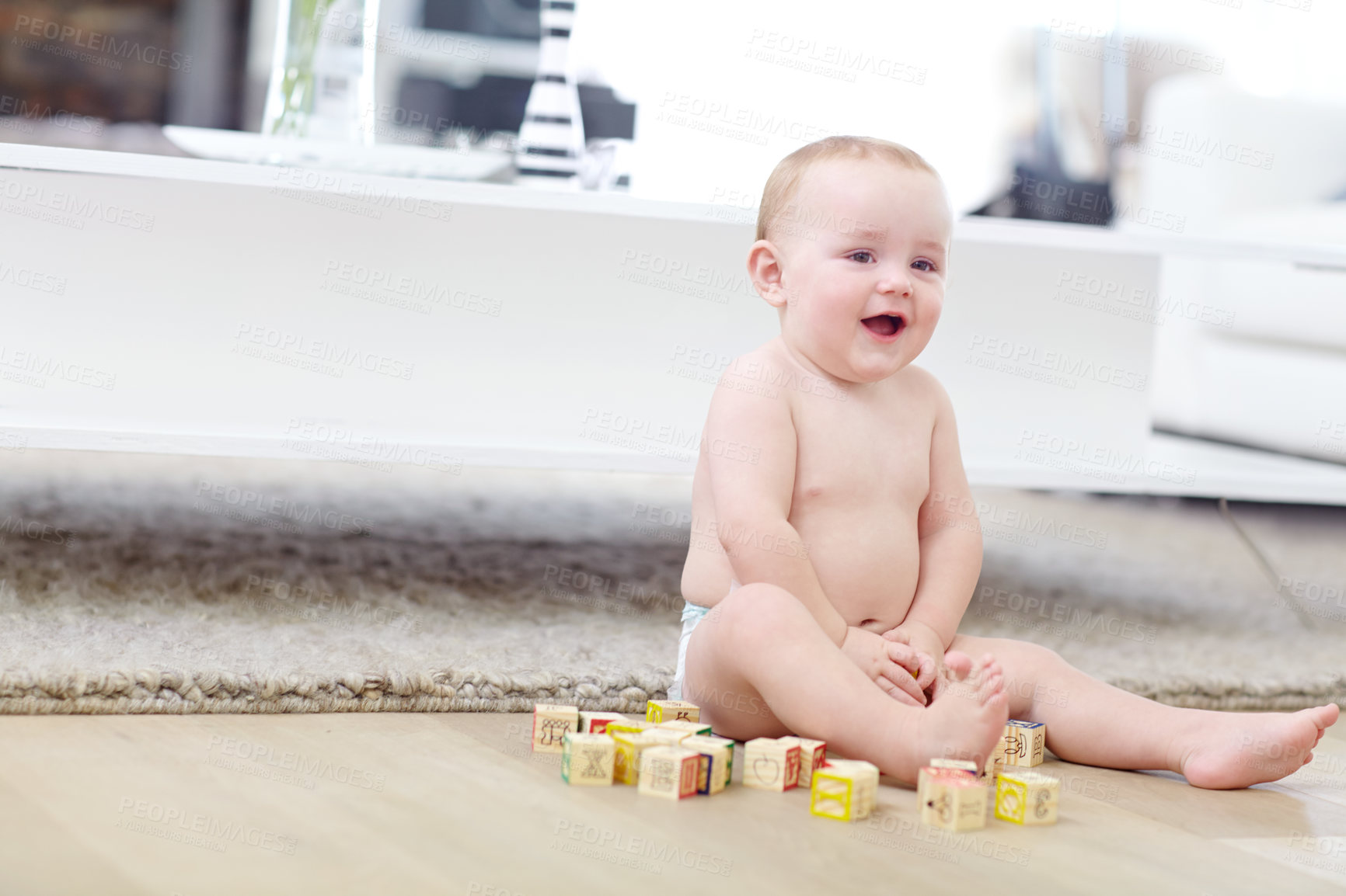 Buy stock photo Shot of an adorable little boy wearing his diaper while playing with his blocks