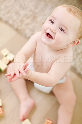 Buy stock photo A cute little boy clapping his hands with his blocks lying next to him