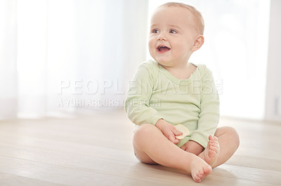 Buy stock photo Shot of a baby boy sitting on the floor while eating a snack