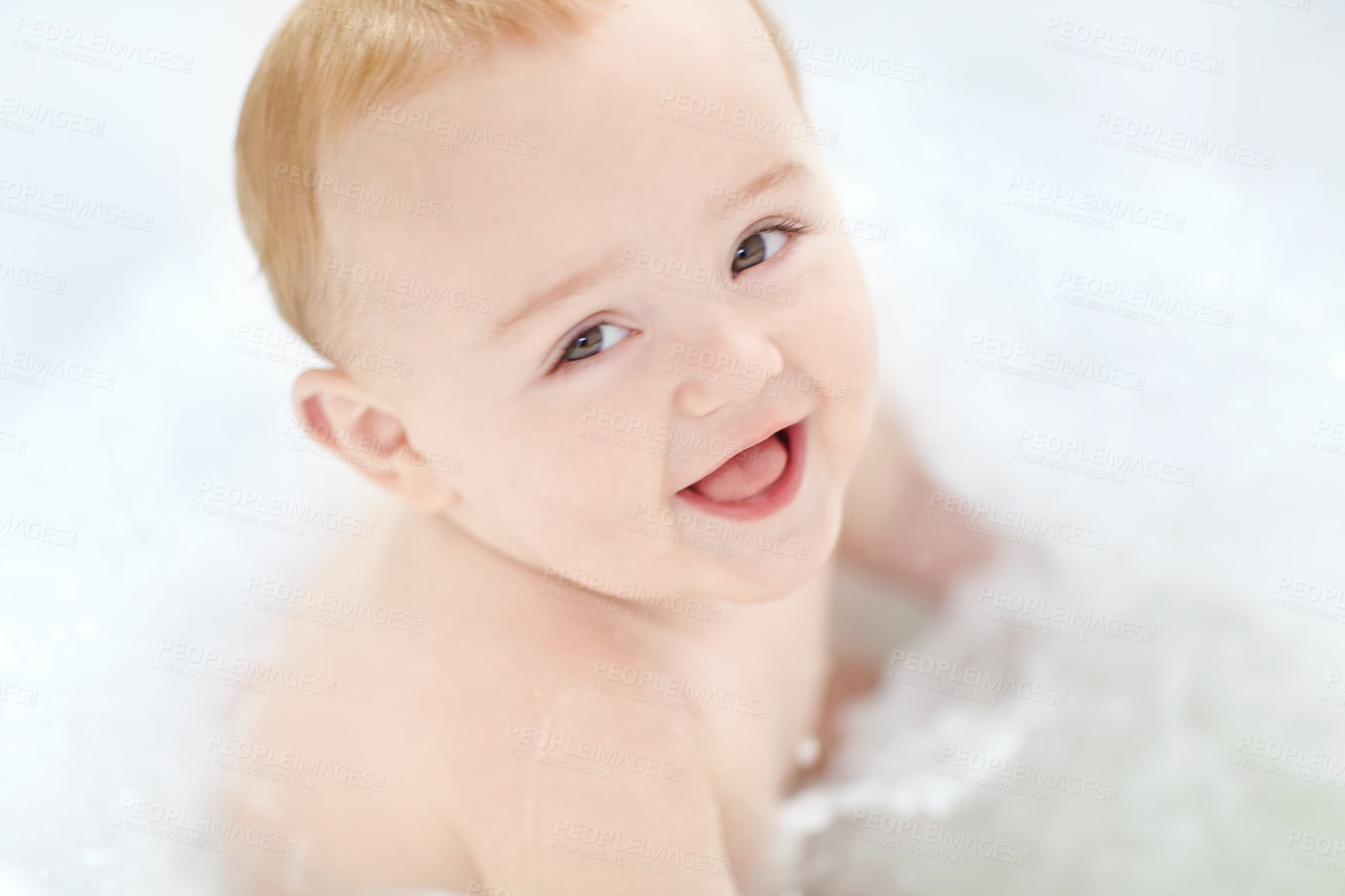 Buy stock photo Shot of an adorable baby boy sitting in a bathtub