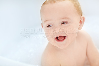 Buy stock photo Shot of an adorable baby boy sitting in a bathtub