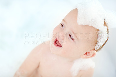 Buy stock photo Shot of an adorable baby boy covered with foam in the bathtub