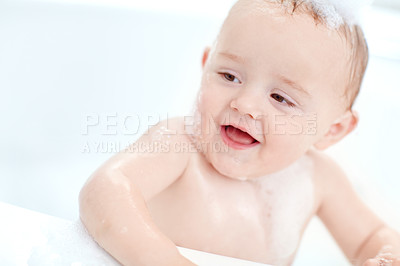 Buy stock photo Shot of an adorable baby boy sitting in a bathtub