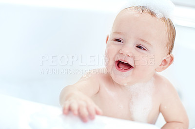 Buy stock photo Shot of a cut baby boy having fun in the bathtub