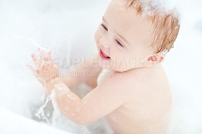 Buy stock photo Shot of a cut baby boy having fun in the bathtub