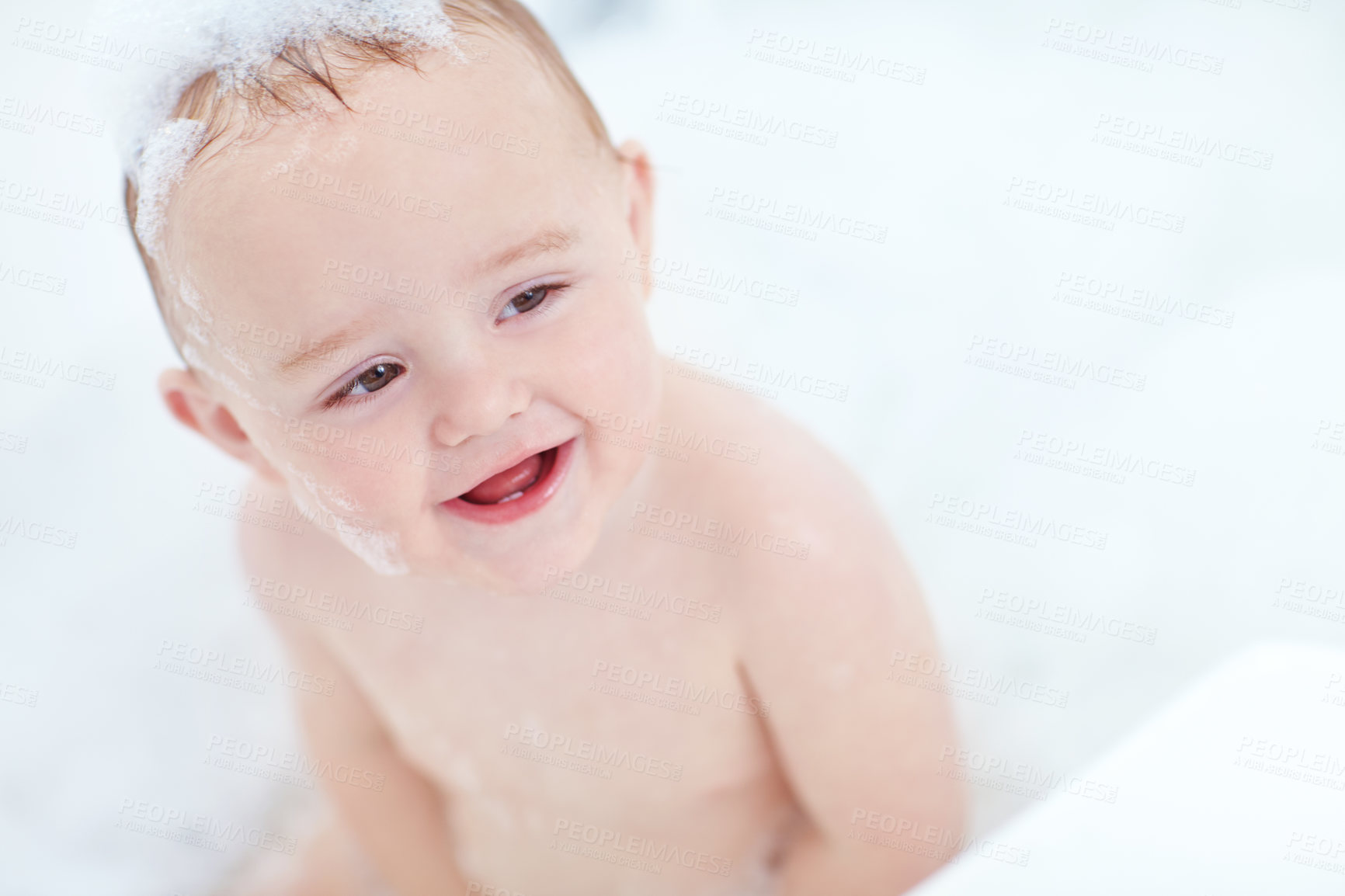 Buy stock photo Bubbles, happy and baby in bathroom for skincare, washing and clean routine at home. Smile, bathtub and cute boy toddler in water with soap foam for hygiene with growth and development in house.