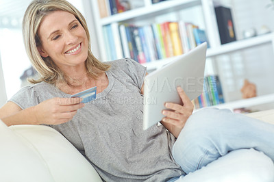 Buy stock photo Shot of an attractive mature woman doing some online shopping at home