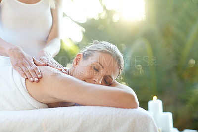 Buy stock photo Shot of an attractive mature woman receiving a massage at a spa