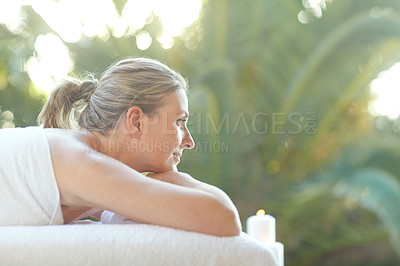 Buy stock photo Shot of an attractive mature woman relaxing on a massage table at a spa