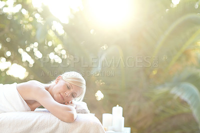 Buy stock photo Shot of a beautiful woman relaxing on a massage table at a spa