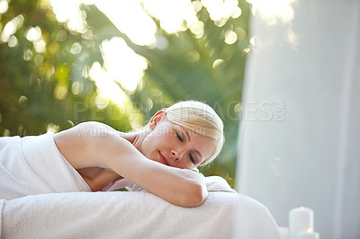 Buy stock photo Shot of a beautiful woman relaxing on a massage table at a spa