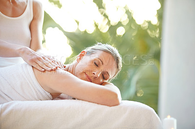 Buy stock photo Shot of an attractive mature woman getting a massage at a day spa